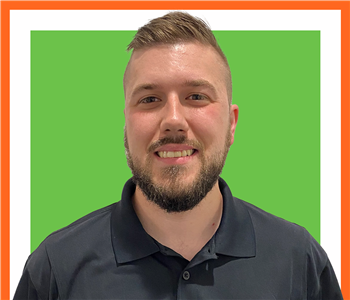 TJ standing against a white background with a SERVPRO logo above him