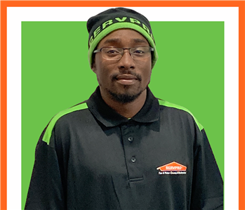 slyvares Light Production technician at SERVPRO in uniform against a green background