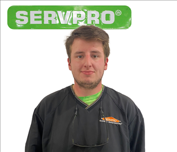 Tristen, SERVPRO employee in front of a green sign, male